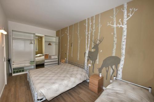 a bedroom with a bed and trees on the wall at Appartamenti Fossato in Tremosine Sul Garda