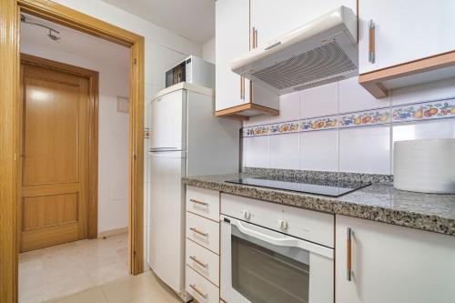 a kitchen with white cabinets and a stove top oven at Sea View of Benidorm in Cala de Finestrat