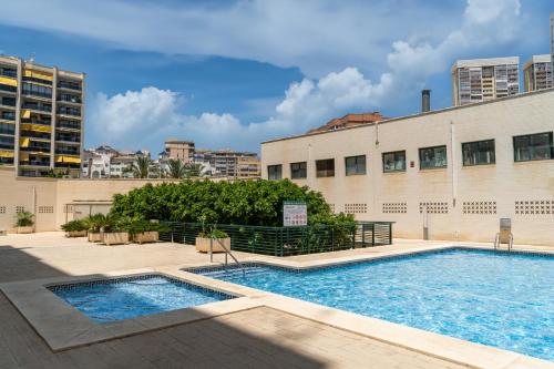a swimming pool in front of a building at Sea View of Benidorm in Cala de Finestrat