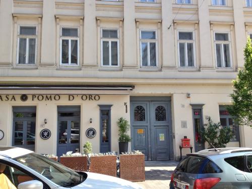 een gebouw waar auto's voor geparkeerd staan bij BpR Auric Home in Boedapest