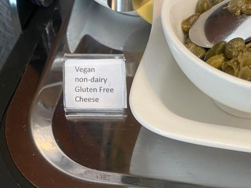 a sign on a plate next to a bowl of olives at Tyndale B&B Torquay in Torquay
