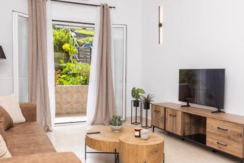 - un salon avec une télévision à écran plat dans un centre de divertissement en bois dans l'établissement Casa Thalia, Kanoni, Corfu, à Kanoni