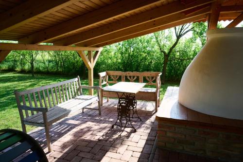 a picnic table and bench under a pavilion at Kőris Tanya in Hódmezővásárhely