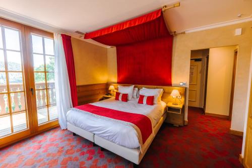 a bedroom with a bed with a red canopy at Les Violettes Hotel & Spa in Jungholtz