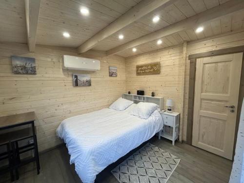 a bedroom with a white bed and a desk at Chambre d'hôte le petit chalet in Sénas