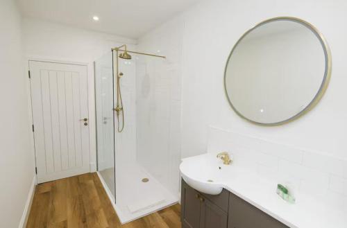 Un baño blanco con lavabo y espejo. en Stylish 3-Bed Apartment in the Heritage Quarter, en Dunfermline