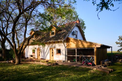 a white house with a gambrel roof at Kőris Tanya in Hódmezővásárhely