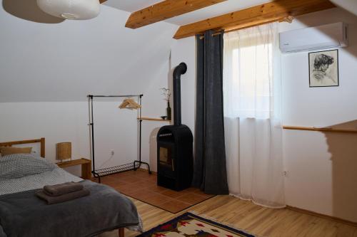 a bedroom with a bed and a window at Kőris Tanya in Hódmezővásárhely