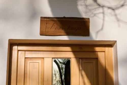 a wooden sign on top of a wooden door at Kőris Tanya in Hódmezővásárhely