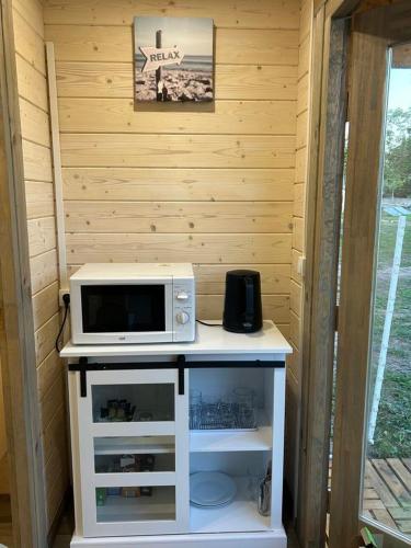 - un four micro-ondes installé sur une table dans l'établissement Chambre d'hôte le petit chalet, à Sénas