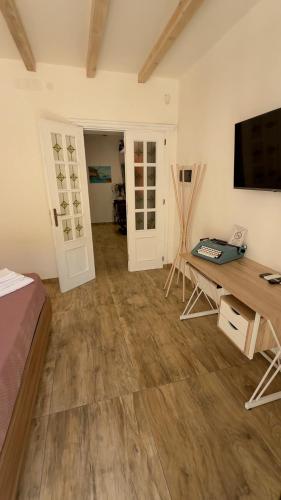 a room with a bed and a desk and a television at My Life in Palermo