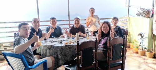 a group of people sitting around a table at Sunshine homestay in Tānsing