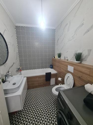 Un baño con inodoro, bañera y lavabo. en Glamour, en Oradea
