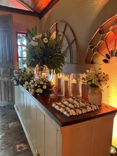 a counter with candles and flowers on top of it at Pousada Charqueada Costa do Abolengo in Pelotas