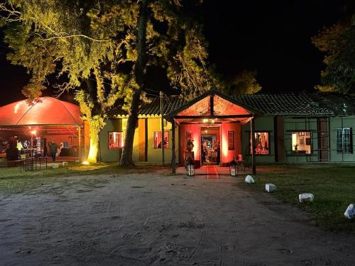 a house with a tent and a tree at night at Pousada Charqueada Costa do Abolengo in Pelotas