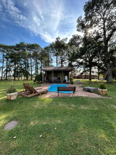 a house with a swimming pool in the grass at Pousada Charqueada Costa do Abolengo in Pelotas