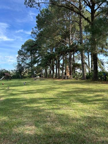 a large grass field with trees in the background at Pousada Charqueada Costa do Abolengo in Pelotas