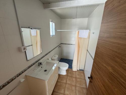 a bathroom with a toilet and a sink and a mirror at Camping Los Naranjos in Moncófar