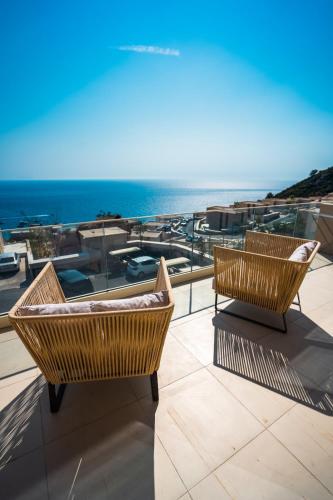 a balcony with two chairs and a view of the ocean at Whisky Green Coast Hotel & Apartments in Palasë