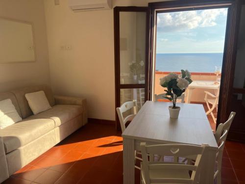 a living room with a couch and a table and a window at Hotel Trinità dei Corsari in Torre Dei Corsari