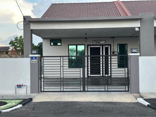 a house with a gate in front of it at Baitul Rahah Homestay Pokok Sena in Pokok Sena