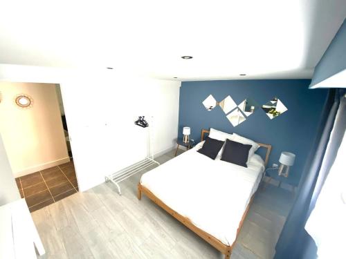 une chambre avec un lit et un mur bleu dans l'établissement Jolie appartement individuel, dans un quartier calme très proche de la plage., à Hendaye