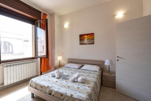 Un dormitorio con una cama y una ventana grande. en Le Torri Sul Mare, en Otranto
