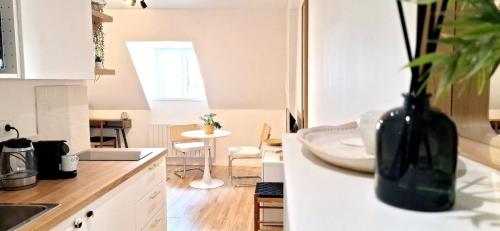 a kitchen with a black vase on the counter at Malpalu St Maclou centre Rouen Linges et ménage inclus in Rouen