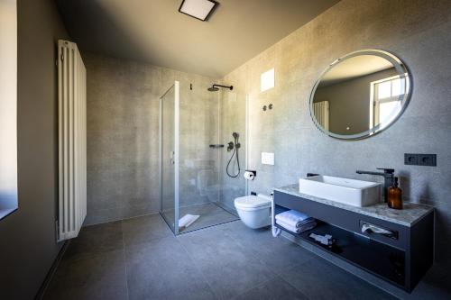 a bathroom with a toilet and a sink and a mirror at Hotel Villa Hirzel in Schwäbisch Gmünd