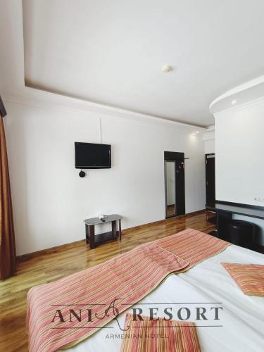 a bedroom with a bed and a flat screen tv on the wall at Ani Resort in Artavaz