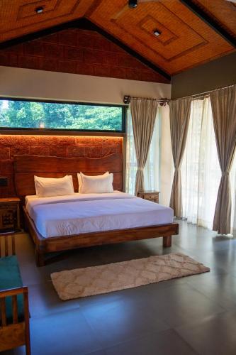 a bedroom with a bed and a large window at Villa Katipadu Coorg in Srimangala