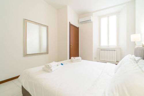 Un dormitorio blanco con dos camas y un espejo. en Como city Flat with AC and WIFI, en Como
