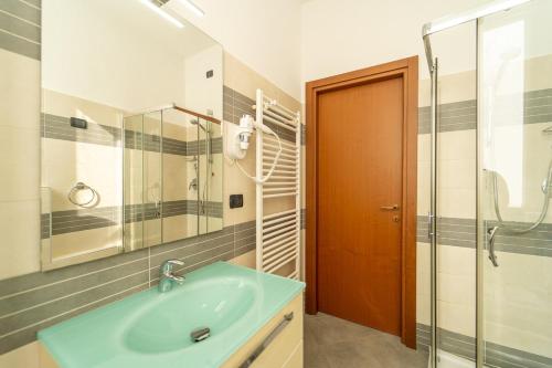 Un baño con lavabo y ducha de cristal. en Como city Flat with AC and WIFI, en Como