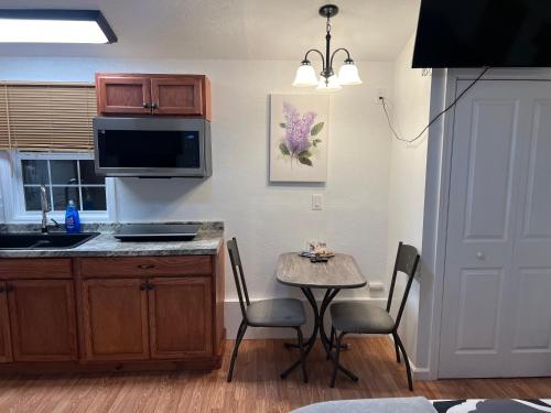 a kitchen with a small table with chairs and a microwave at Micosta Leisure Inn in Hudson