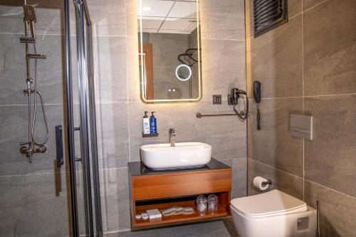 a bathroom with a sink and a shower and a toilet at Rest by Dedeman Elbistan in Elbistan