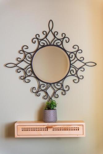 a mirror on top of a shelf with a plant at Villa Aurora in Athanion