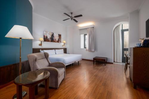 a hotel room with a bed and a chair at Senator Cádiz in Cádiz