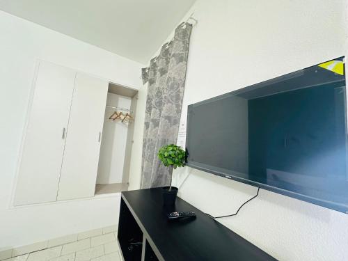 a large flat screen tv hanging on a wall at Central Atlantic Beach Guesthouse in Costa da Caparica