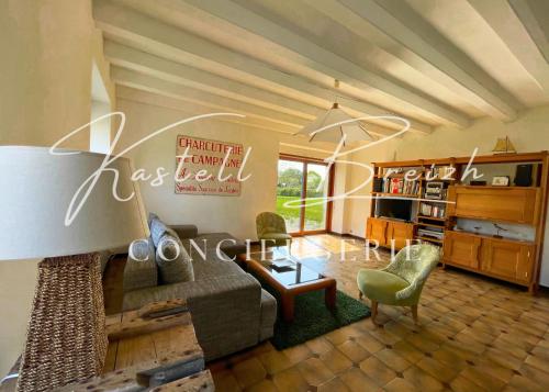 un salon avec un canapé et une table dans l'établissement Maison et Jardin Ar Fardo by Kastell Breizh Conciergerie, à Goudelin