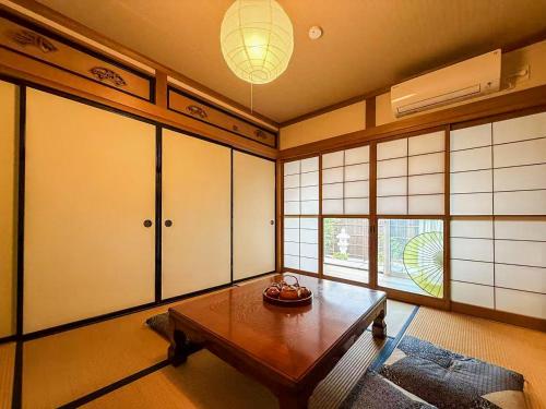 a living room with a table and some windows at 楓の宿 高山市中心 新改装三卧室独栋住宅 周边多个大型超市 至星巴克步行六分钟 两个免费停车位 in Takayama
