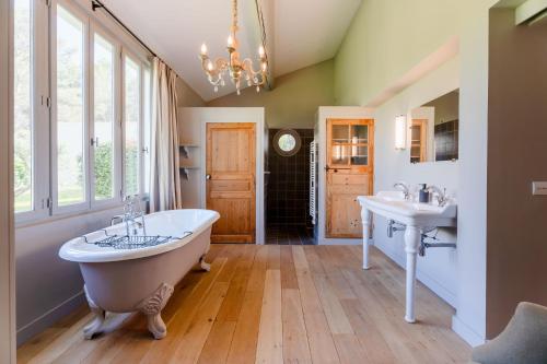 een grote badkamer met 2 wastafels en een bad bij Propriété d'exception - Piscine et Tennis in Venelles