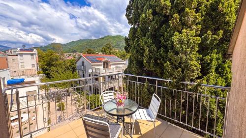 Un balcón con una mesa y sillas en un balcón. en Qumi Apartments, en Tivat