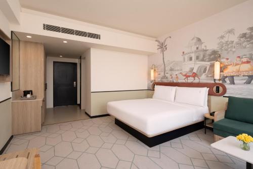 a bedroom with a white bed and a couch at Holiday Inn Gurgaon NH8 by IHG in Gurgaon
