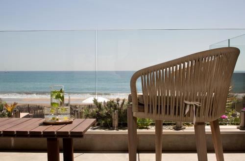 una sedia di legno e un tavolo con vista sulla spiaggia di Villa Miramar Frontignan a Frontignan