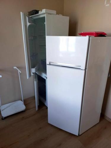 Zimmer mit einem weißen Kühlschrank und einem Schreibtisch in der Unterkunft Loksa laagripaik in Loksa