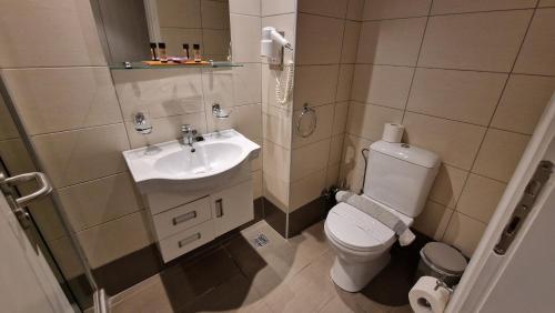a small bathroom with a toilet and a sink at Cosmopolitan Hotel in Kos Town