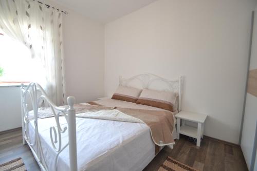a bedroom with a white bed and a window at Villa Pistan in Murvica