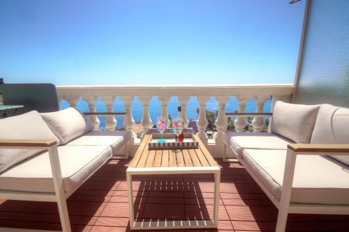 Elle comprend un balcon doté d'un mobilier blanc, d'une table et de chaises. dans l'établissement Appartement vue mer plage à pied, à Saint-Raphaël