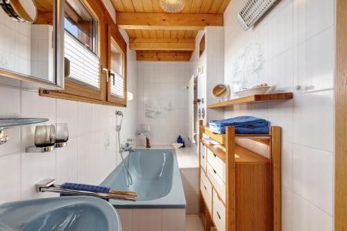 a bathroom with a blue tub and a sink at Schwalbennest in Bodman-Ludwigshafen