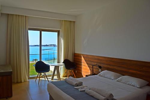 a bedroom with a bed and a view of the ocean at Amphora Hotel & Suites in Paphos City